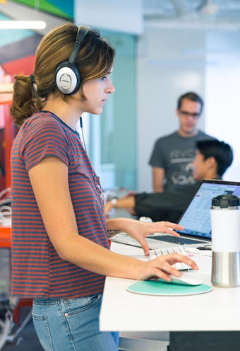 A designer at a standing desk at Acorns